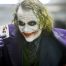 Heath Ledger as the Joker holding up a joker playing card